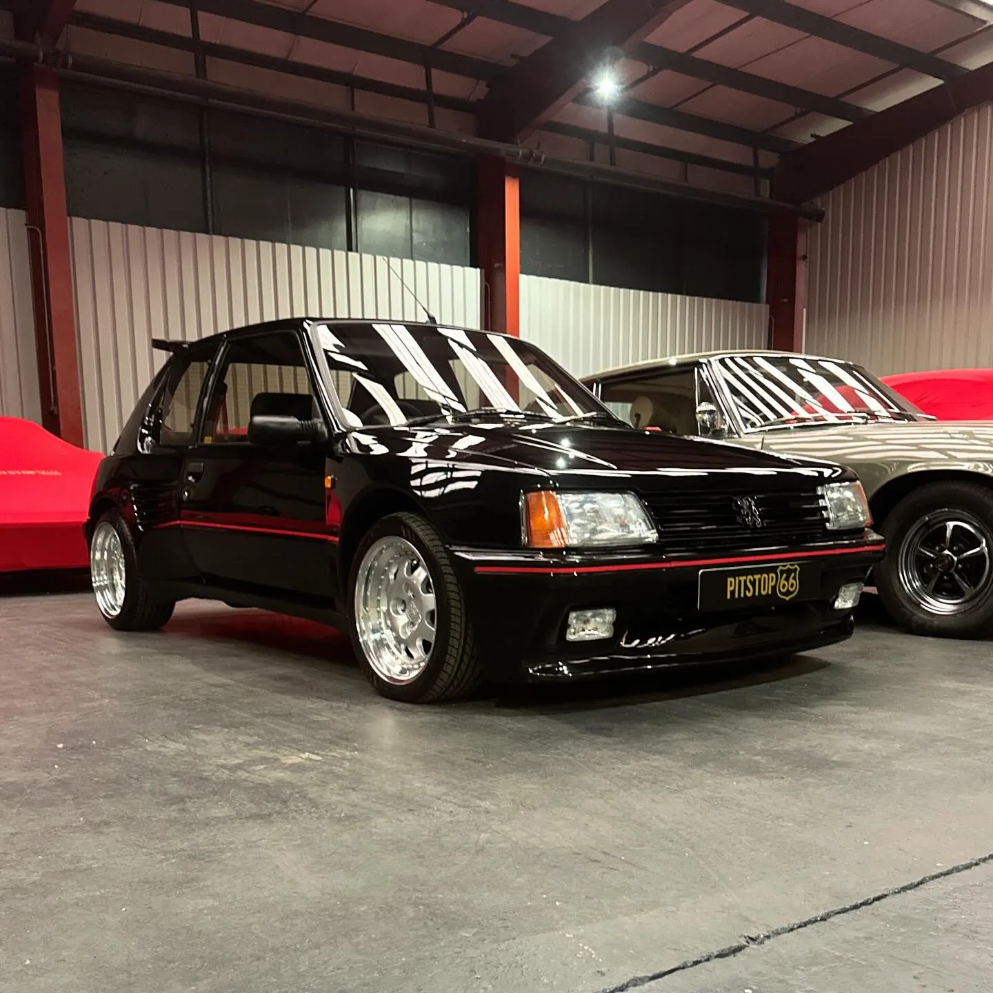 Classic black car stored in a secure indoor vehicle storage facility.